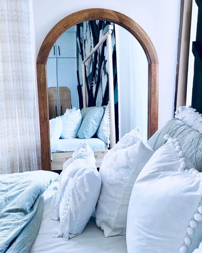 19. Anchor a Cozy Nook with a Wood-Framed Arch Mirror