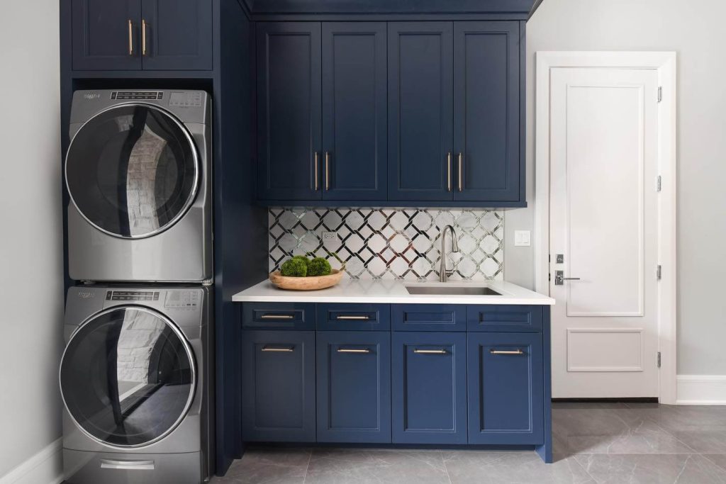 2. Bold Navy Cabinets with Reflective Backsplash Flair