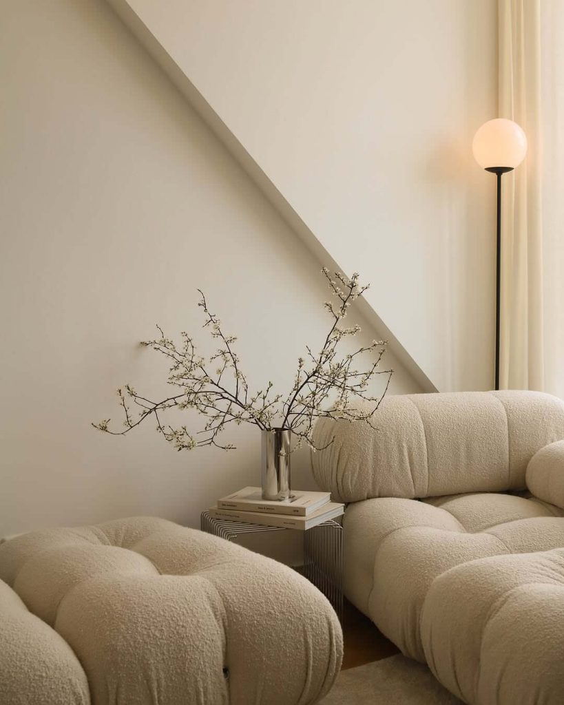 31. Japandi Interior Ideas Curved Sofa and Branch Decor