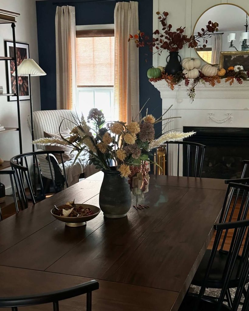 34. Layer Dark Accents and Natural Florals for a Moody Autumn Dining Space
