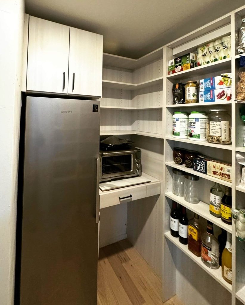 6. Slim Walk-In Pantry with Built-In Workspace and Fridge Integration