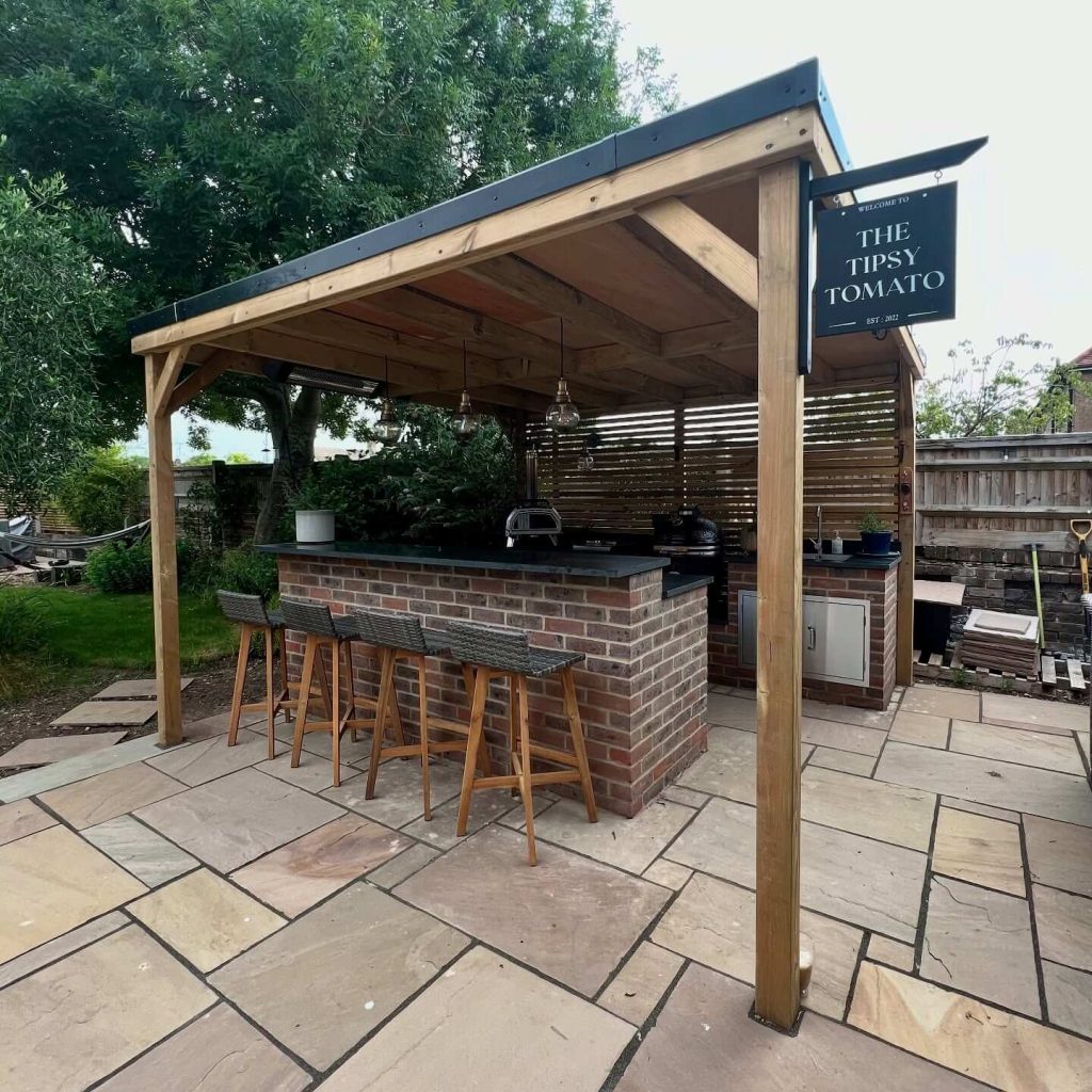 7. Backyard Pub Vibes with Brick Bar and Pergola